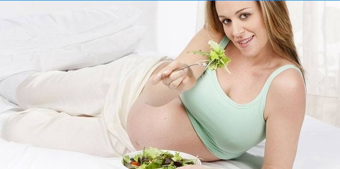 Gravid jente spiser salat