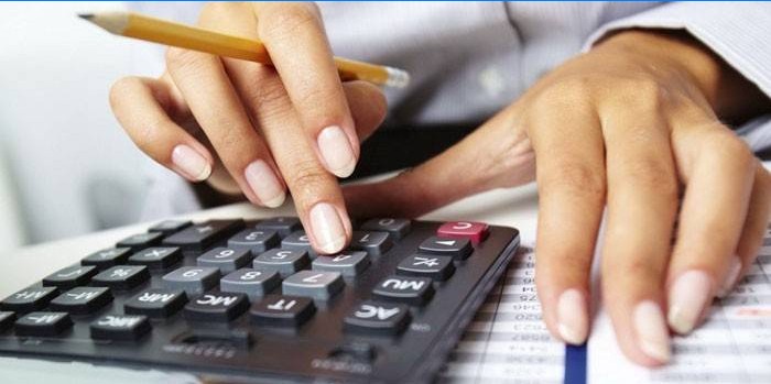 Kvinne teller på en kalkulator