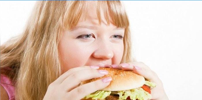 Jente spiser en hamburger