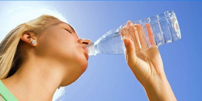 Jente drikker vann fra en flaske