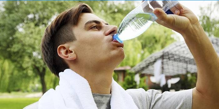 Mannen drikker vann fra en flaske