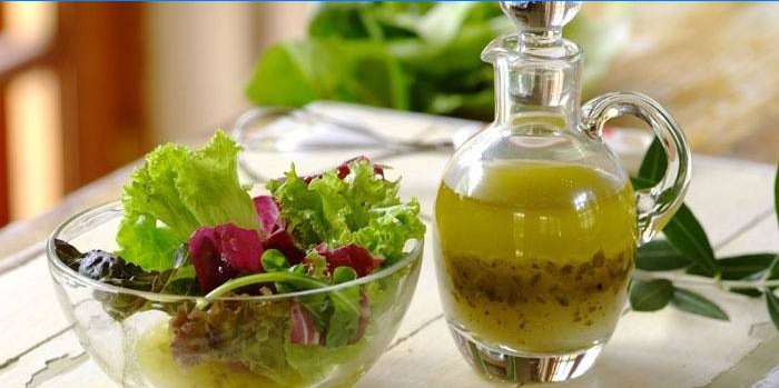 Salatblader i en bolle og ferdig dressing til dressing