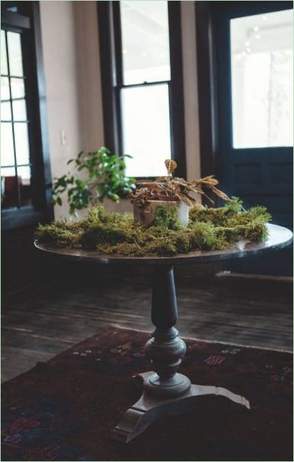 Interiøret i huset i en rustikk stil: et bord med mose
