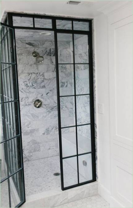 Interiøret i et stort hus: marmorfliser i dusjen