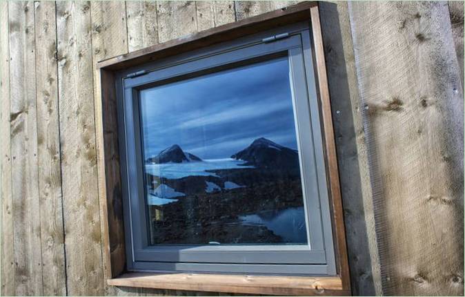 Rabothytta hytter i fjellene I Nord-Norge: refleksjon av landskapet i vinduet