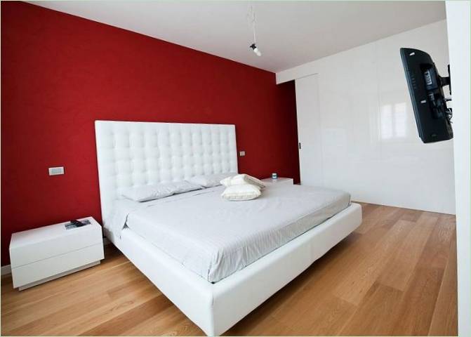 Rød vegg og hvit seng på soverommet