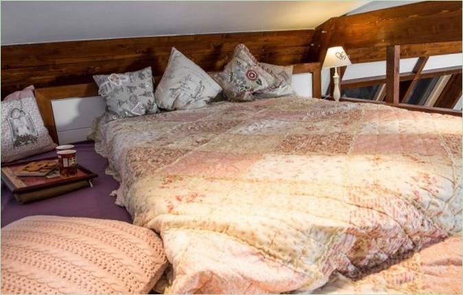 En luksuriøs seng med puter og en plaid i stil med romantikk