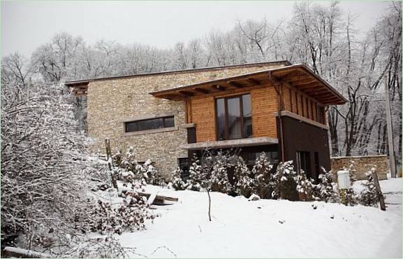 Moderne stein herregård i en snødekt skog