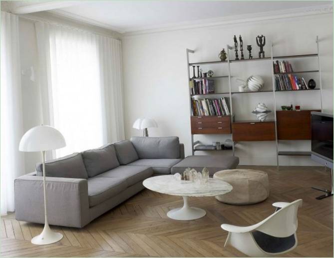 Koselig stue med store vinduer og lyse stoppede møbler